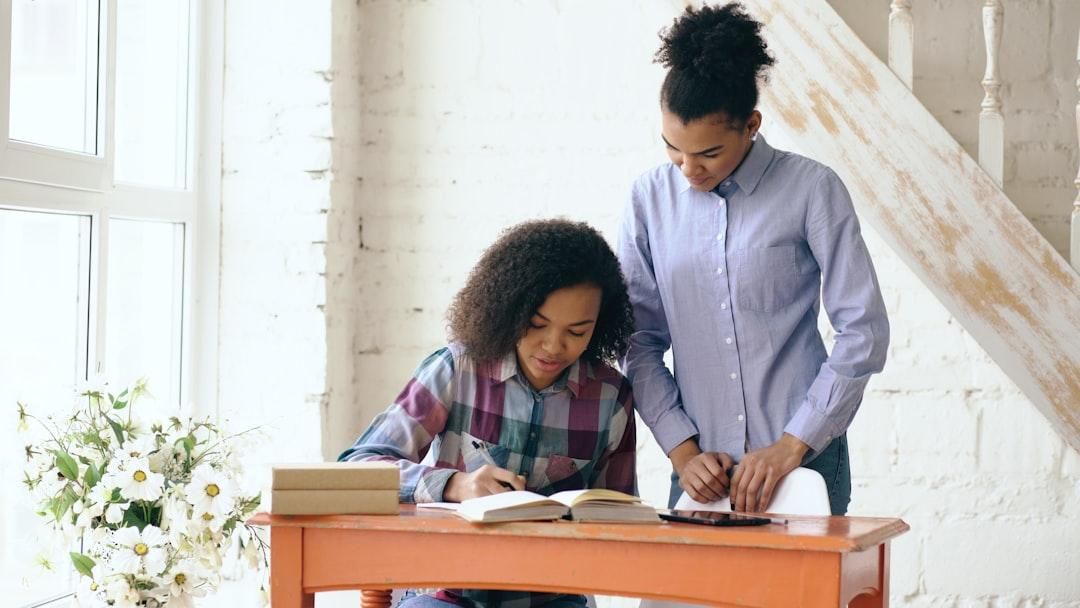 Adulte qui guide une enfant pendant ses devoirs